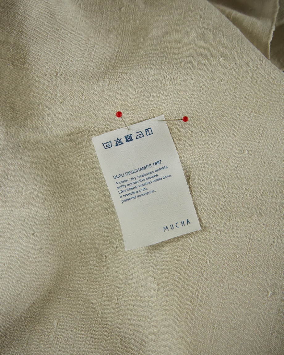 イメージ写真：リネン生地にまち針で留め付けられた洗濯表示